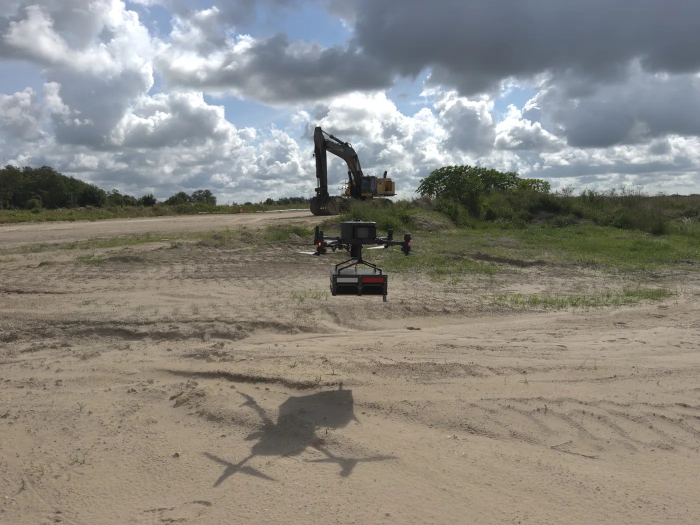 Drone-mounted ground penetrating radar antenna in flight over an active site