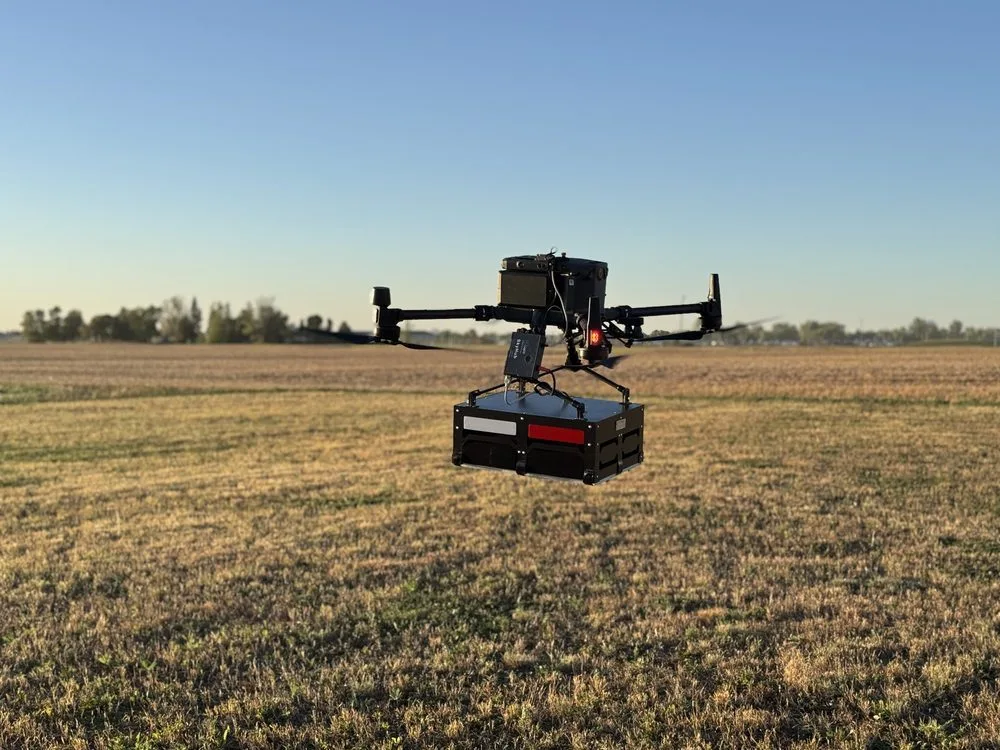 Drone-mounted GPR platform flying low over soft vegetated ground during a subsurface survey