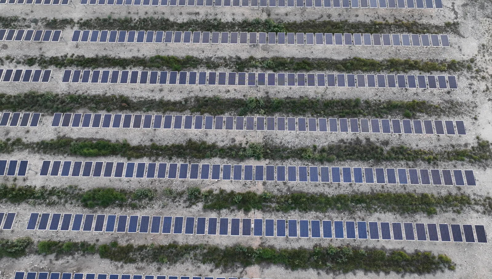 Aerial drone view of a utility-scale solar array — rows of photovoltaic modules photographed during a Northern Drone site survey